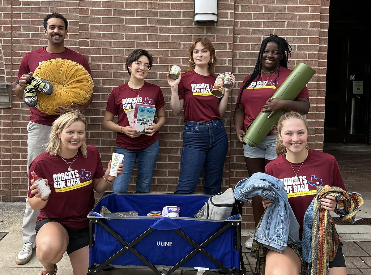 students posing around recycling items